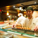 A Sushi Chef serving a roll at Sushi Village in Whistler