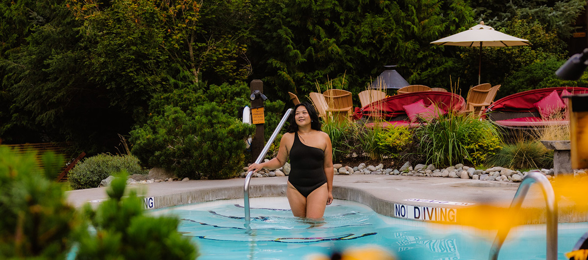 A relaxed-looking person entering a pool at a spa
